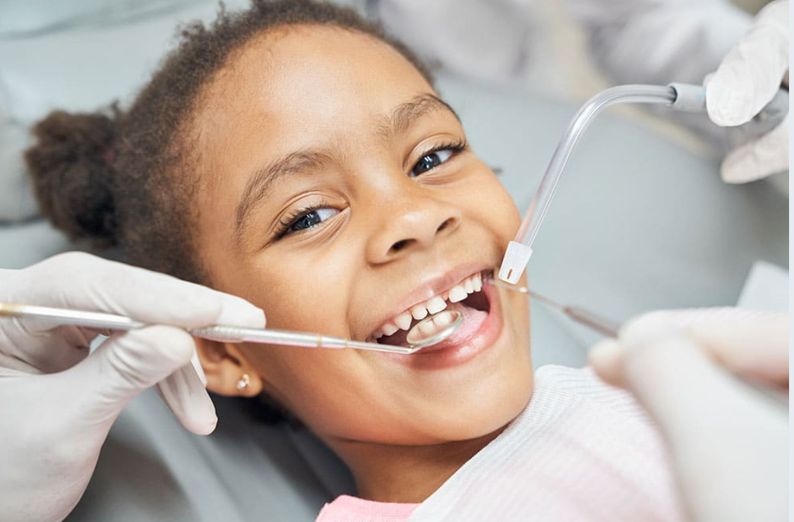 Young child smiling during a gentle dental examination